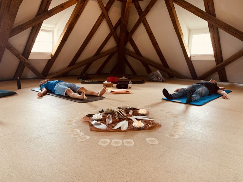 Breathwork-Workshop in Winterthur: Teilnehmende liegen auf Matten unter einem Dachstuhl aus Holz